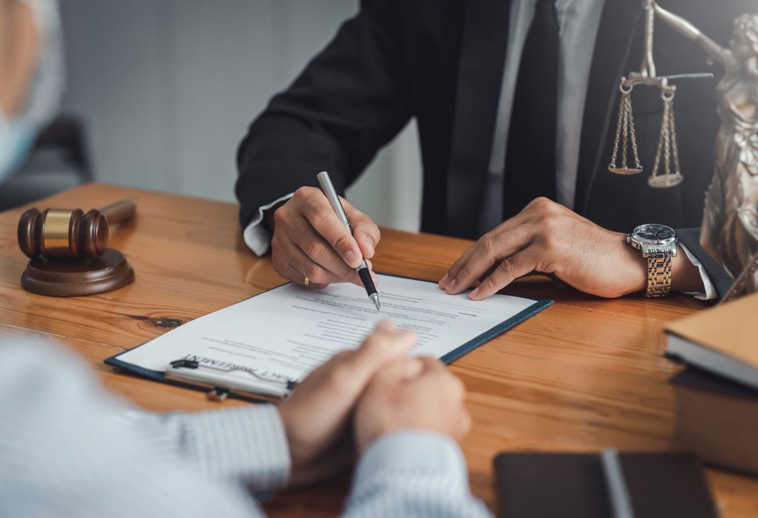 A suited judge writing on a clipboard in front of another well dressed client representing Debt Collection Litigation Firms.