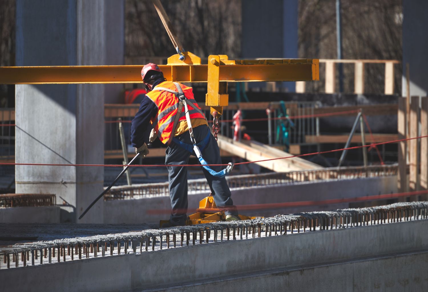 Collection Services Improve B2B Construction Firms: Construction Site Worker with Safety Harness Hook